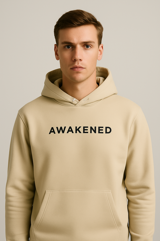 Male model in studio wearing Desmond & Florence AWAKENED hoodie in Desert Dust color, clean look with minimal black embroidery